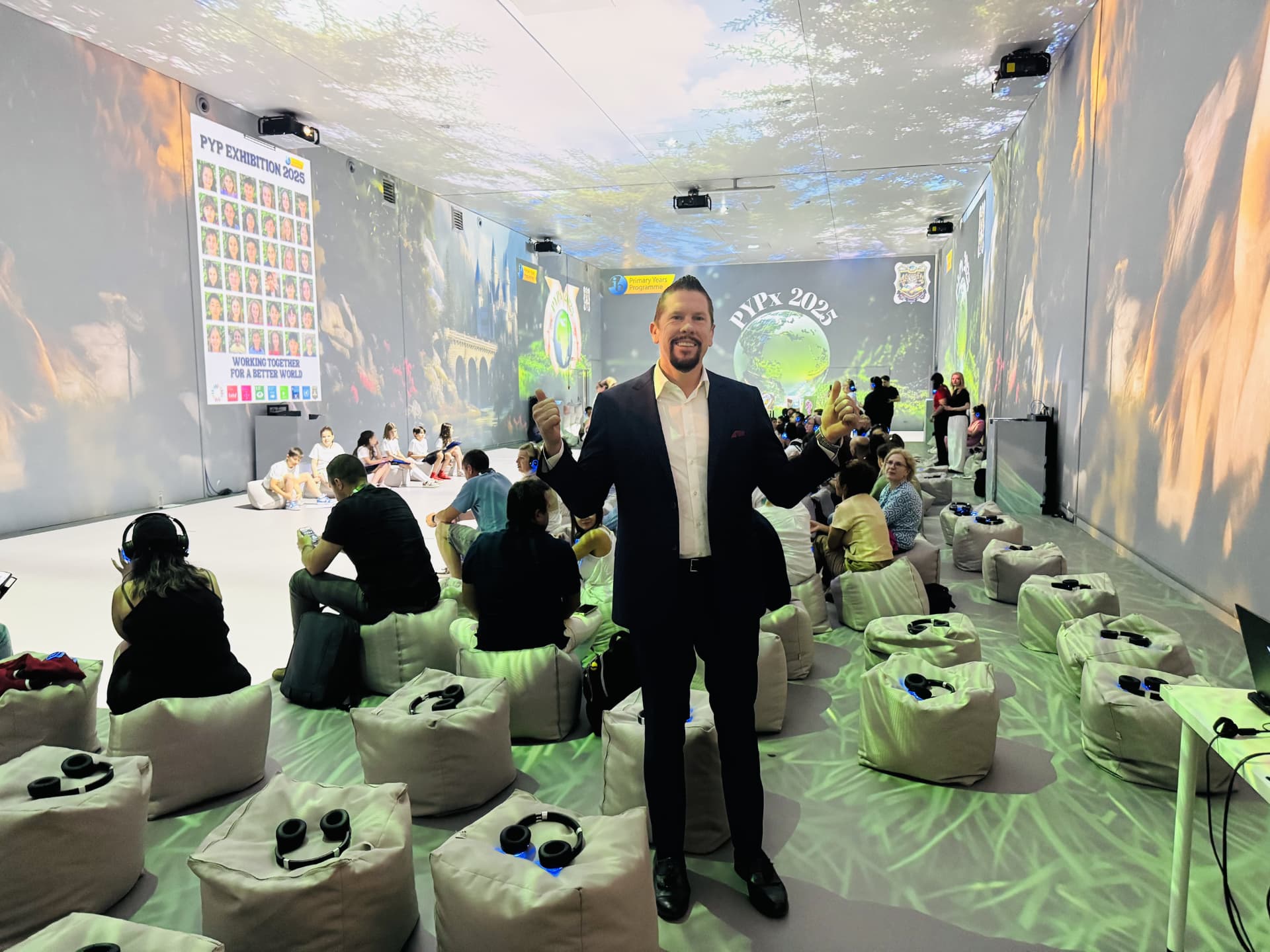 Dr. Wilkens at the PYP Exhibition immersive learning space with students